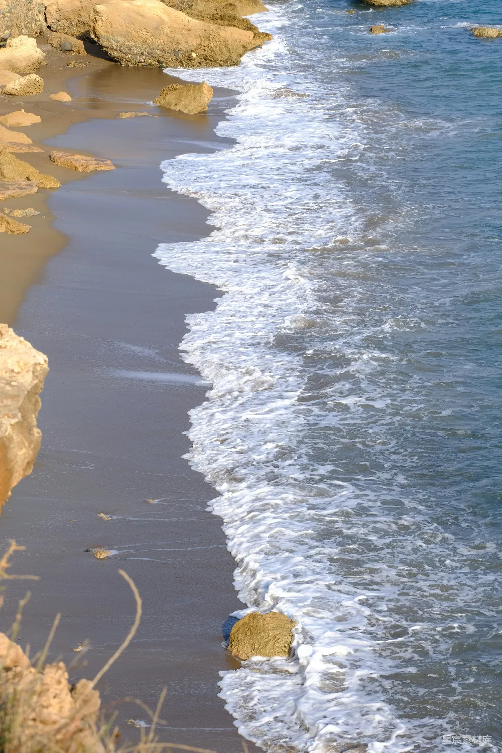 高清摄影 自然 波浪轻轻地拍打着沙滩上的岩石露头。