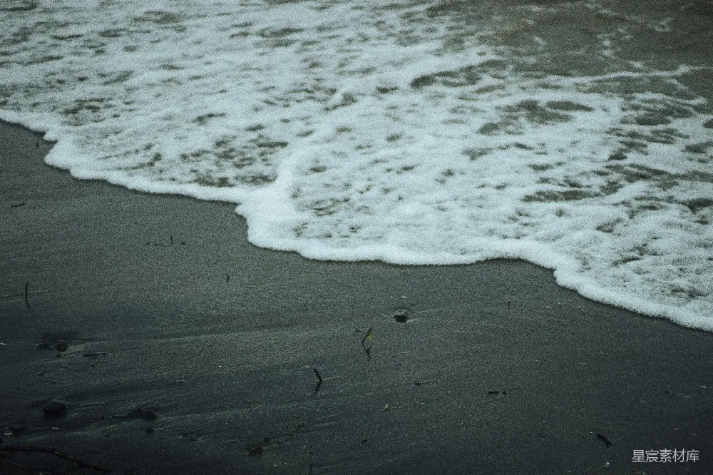 高清摄影  海浪轻轻拍打着黑暗的沙滩。