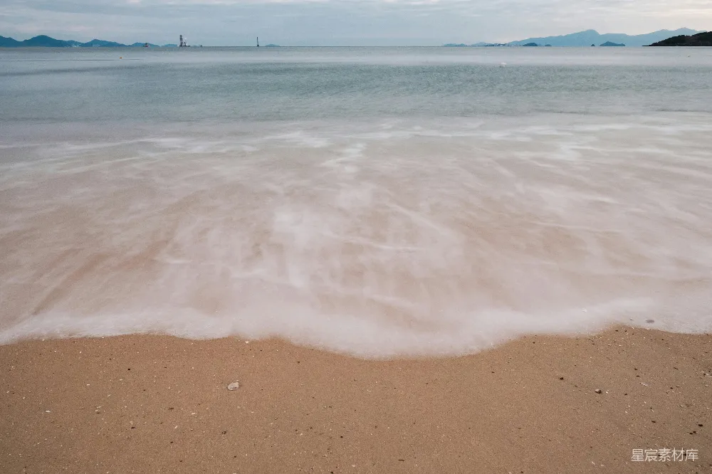 高清摄影  黄昏时分，温柔的海浪轻抚着沙滩。