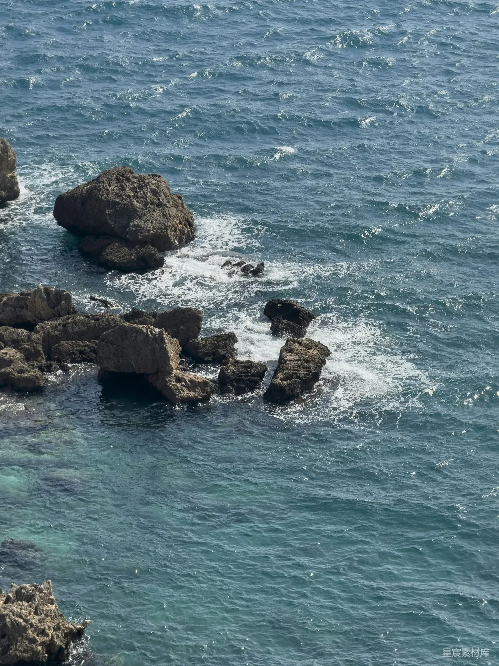 高清摄影  几块石头坐在水体中央。