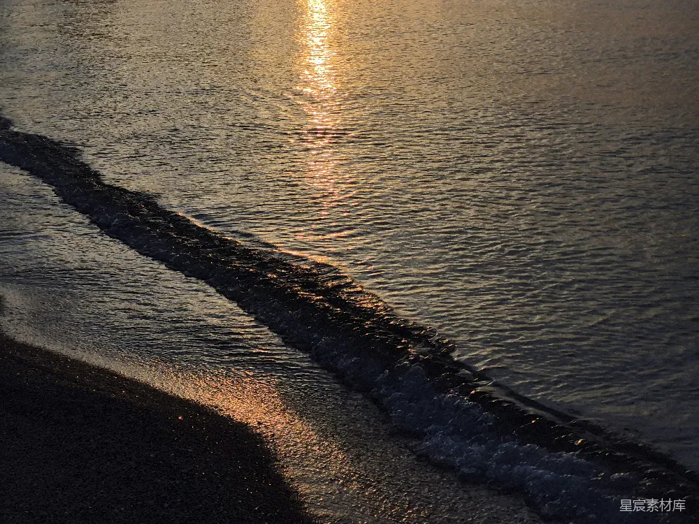 高清摄影  夕阳下，温柔的波浪轻拍着黑暗的海岸。