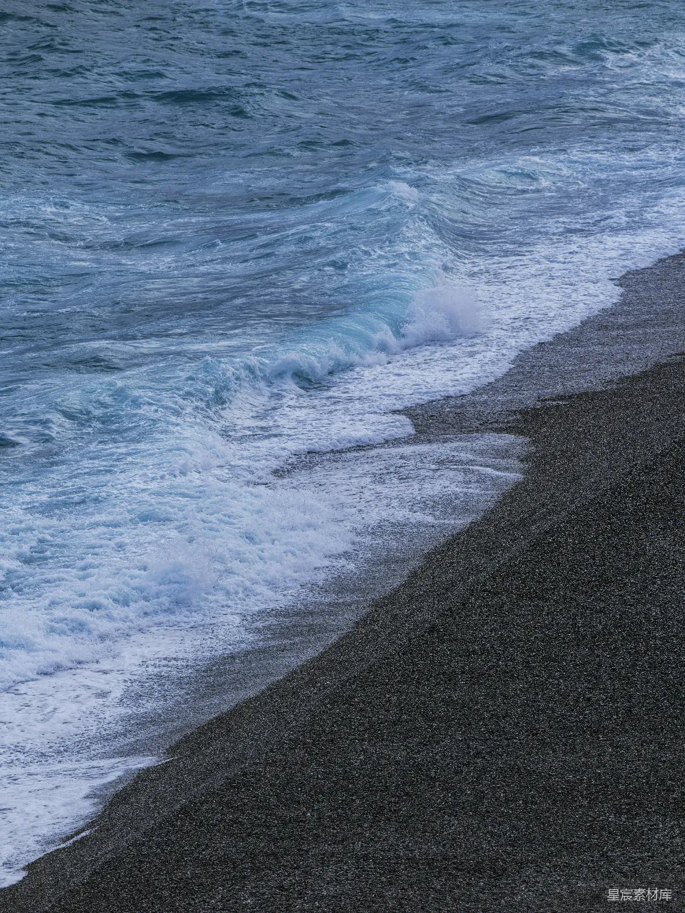 高清摄影  海浪拍打在卵石海滩上。