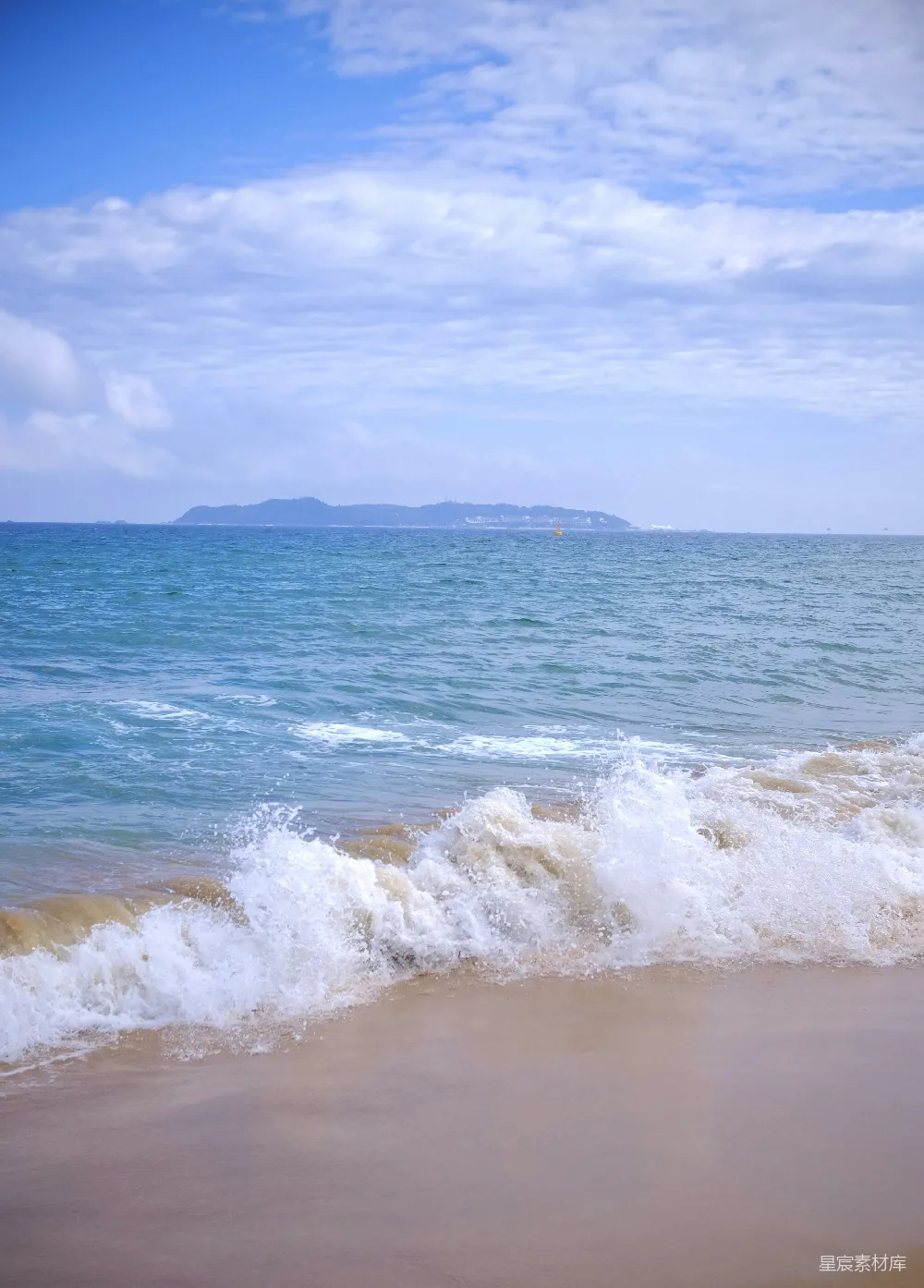 高清摄影  海浪拍打着沙滩，远处是岛屿。