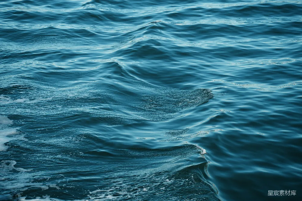 高清摄影  深蓝色的海洋波浪特写，波浪上泛着白色的泡沫。