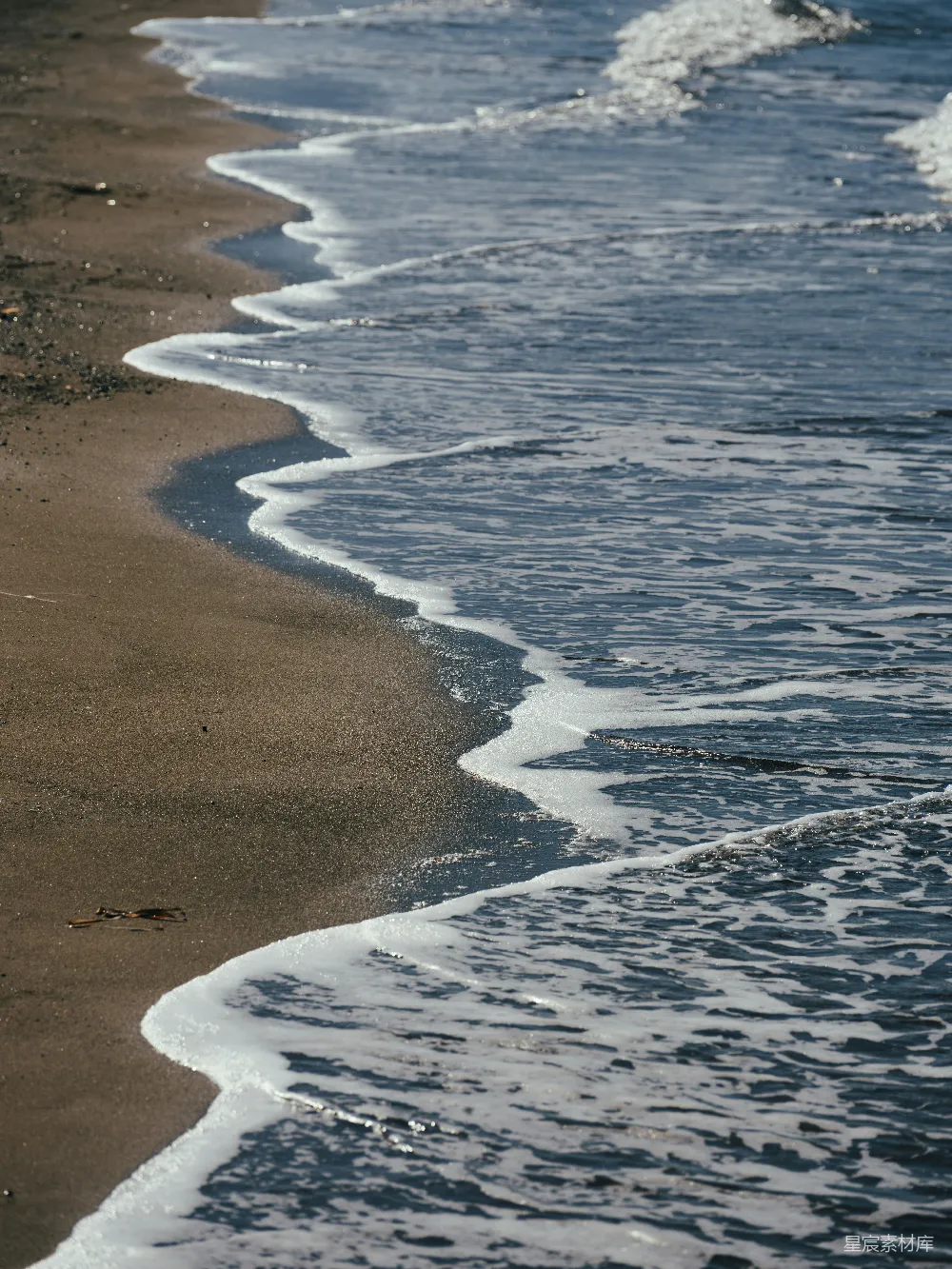 高清摄影  海滩上，海浪拍打着岸边。