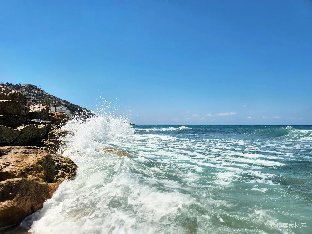 高清摄影  在阳光明媚的一天，海浪冲撞着岩石。