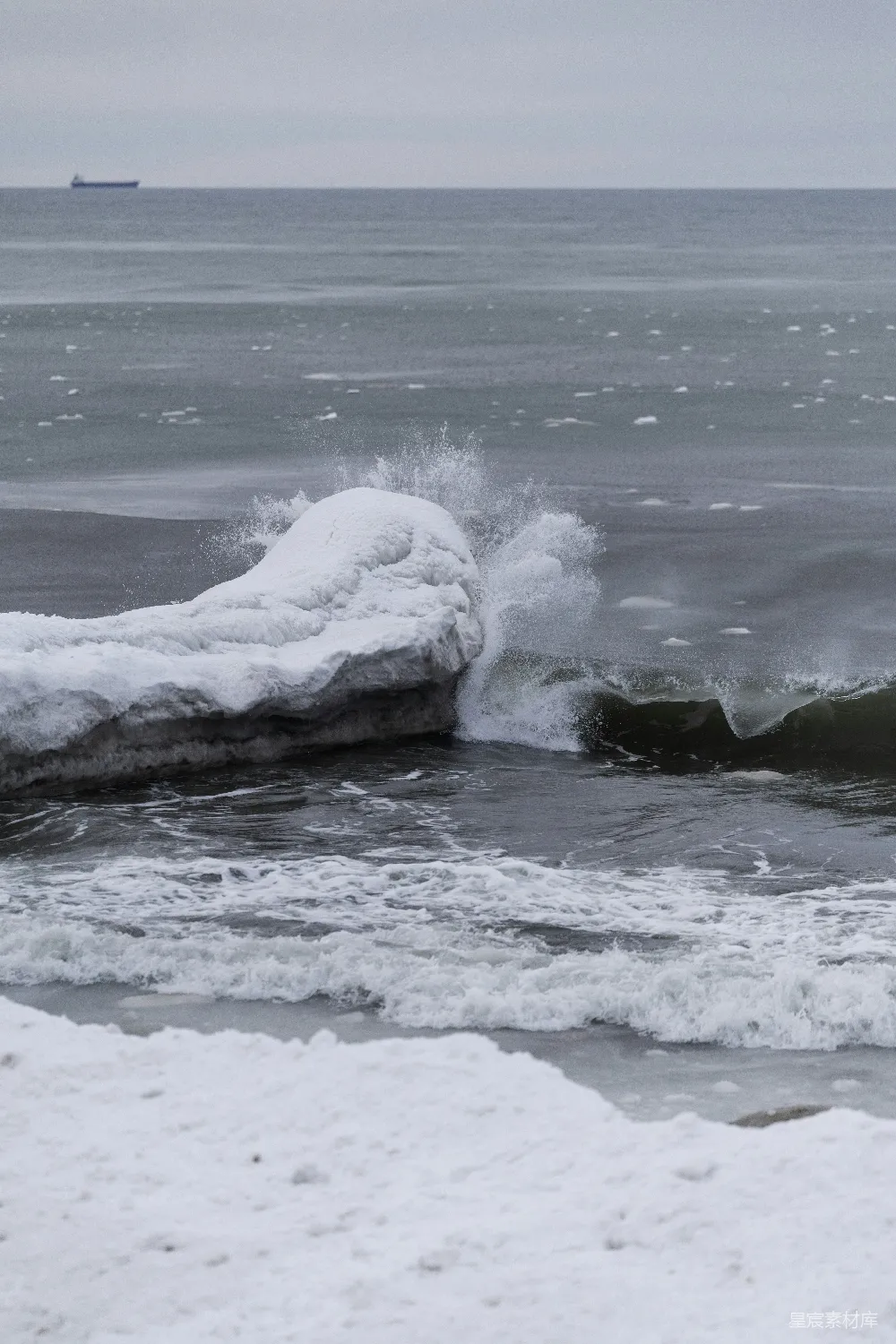 高清摄影  海浪拍打着覆盖着雪的冰岸