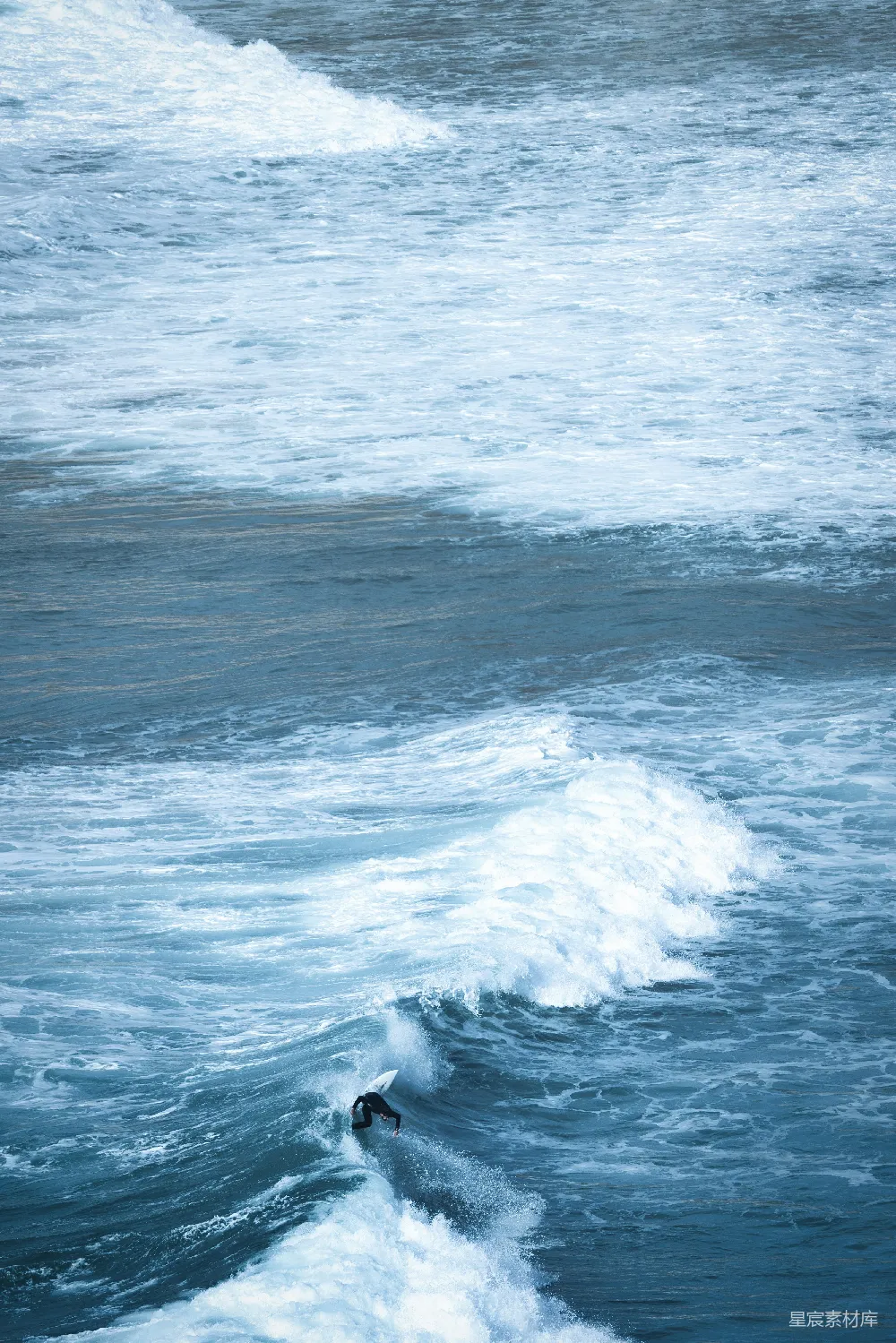 高清摄影  一个男人在冲浪板上骑着海浪