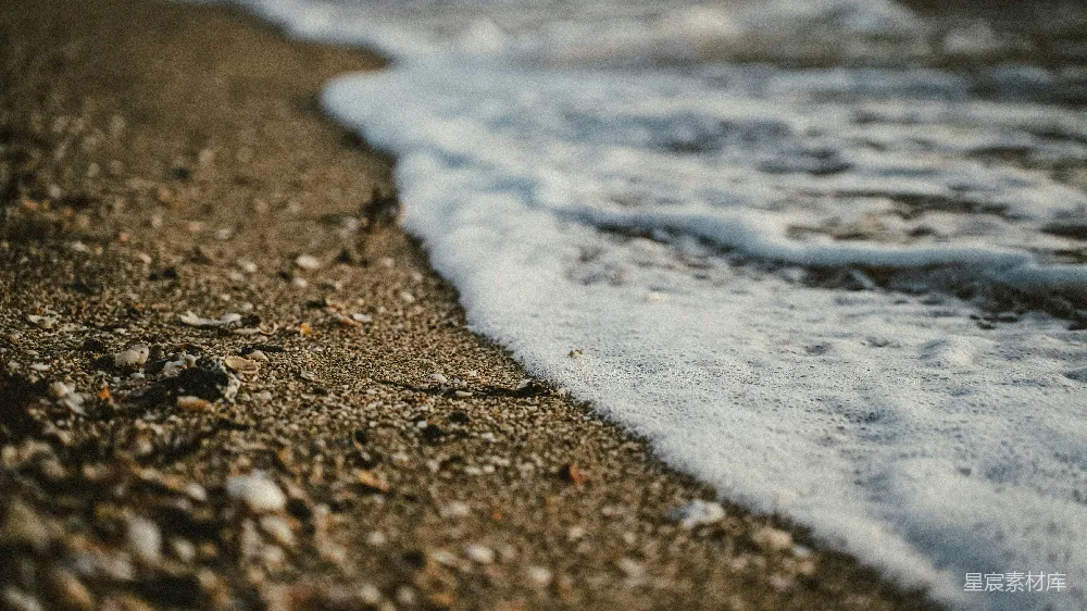 高清摄影  泡沫般的海浪拍打着沙滩。