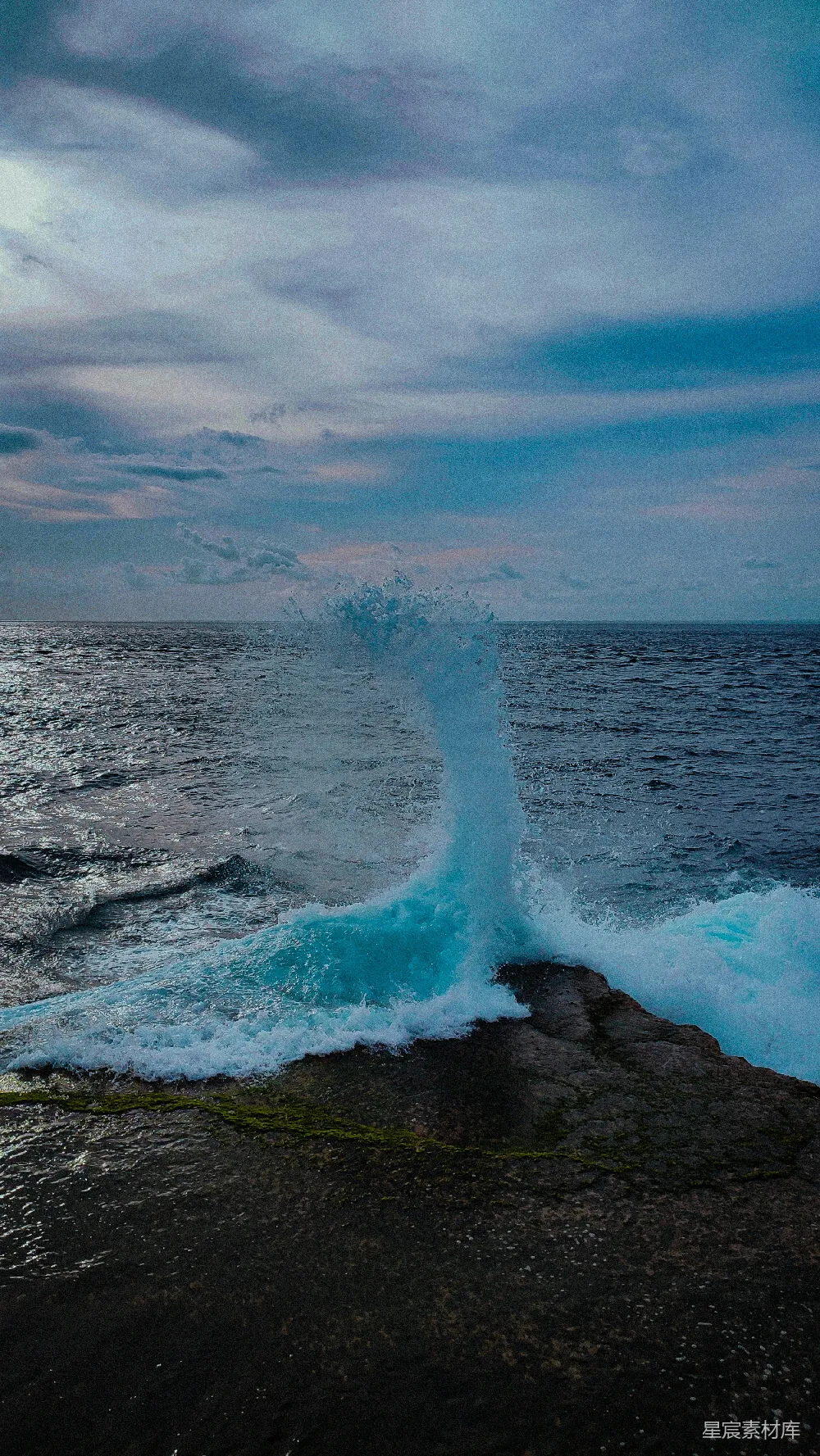 高清摄影  在阴云密布的天空下，海浪拍打着岩石海岸。