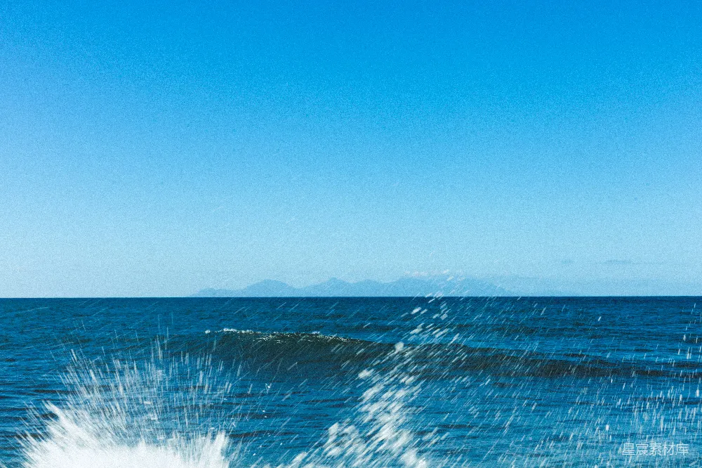 高清摄影 自然 清澈的蓝天下的波涛汹涌的大海和远处的山脉