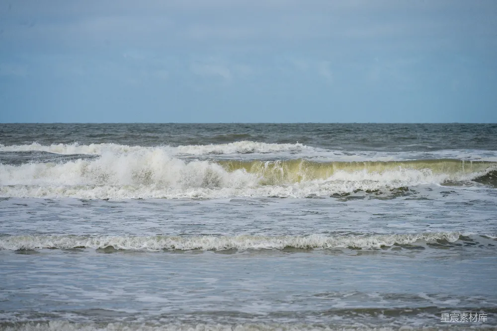 高清摄影  阴沉天空下波涛汹涌的海水，海面上泛起白色的泡沫。