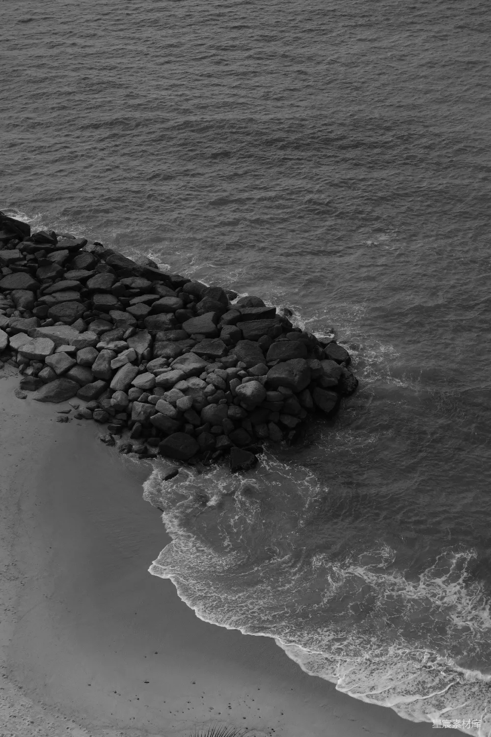 高清摄影  岩石护岸延伸至海中，海浪拍打着岸边。
