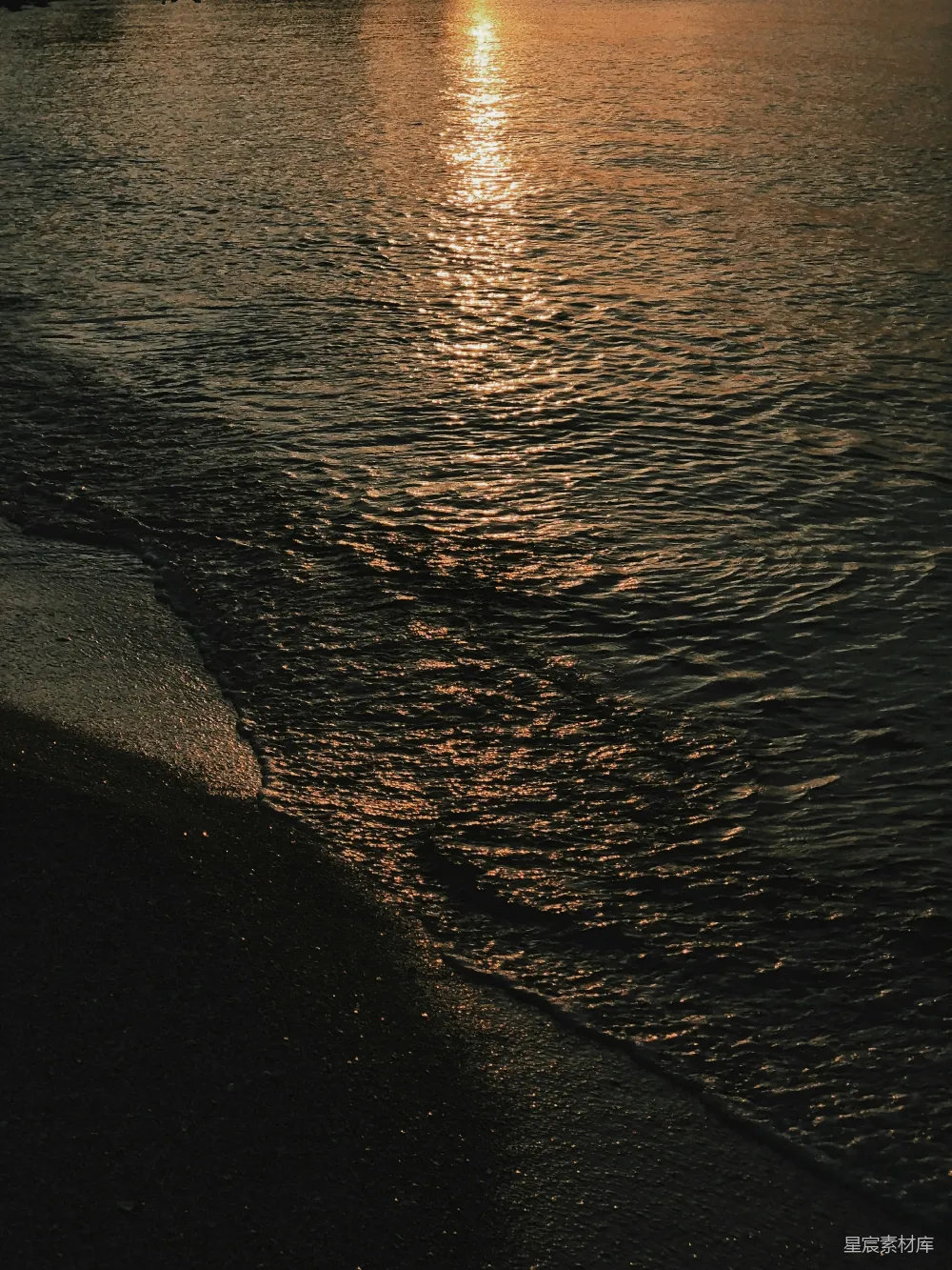 高清摄影  金色的夕阳映照在深色、波光粼粼的海面上。