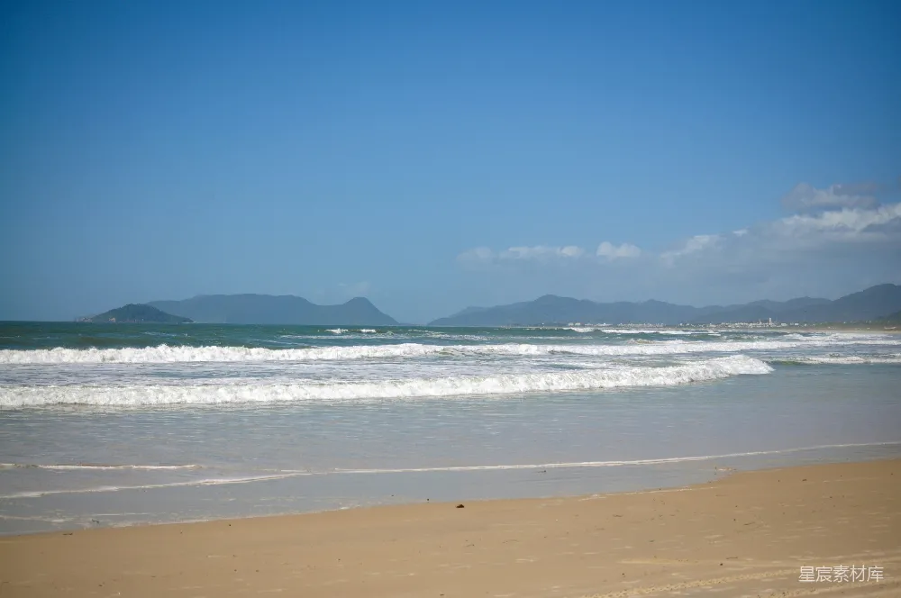 高清摄影  海浪轻轻地拍打着沙滩，在晴朗的天空下。