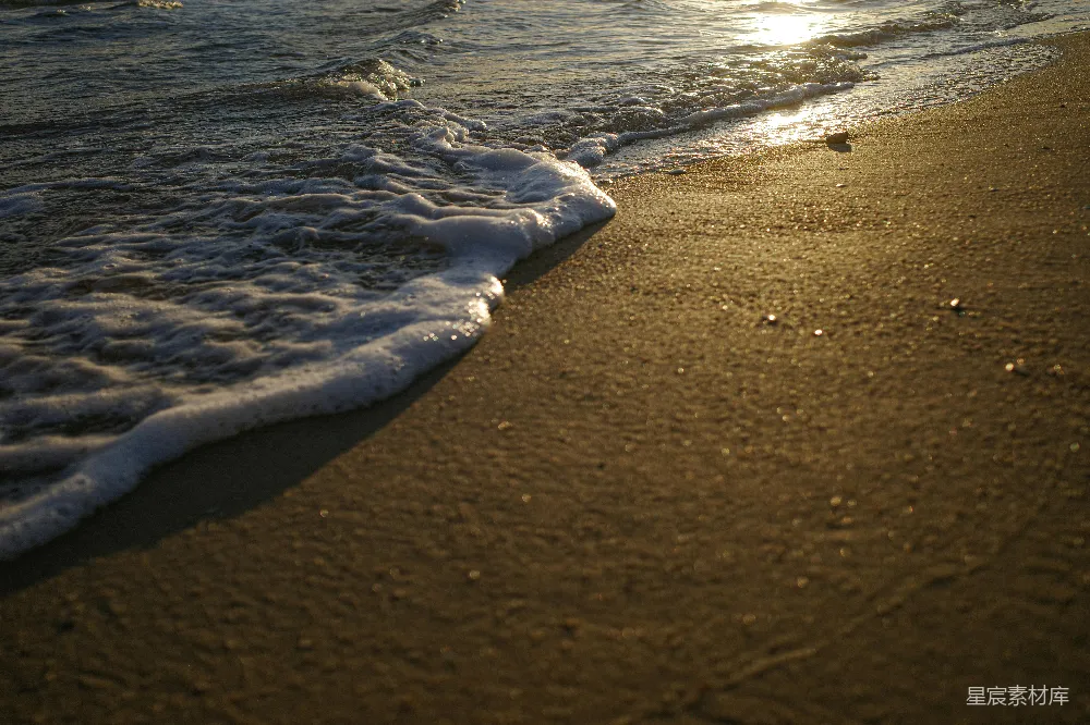 高清摄影  夕阳下，温柔的海浪拍打着沙滩。