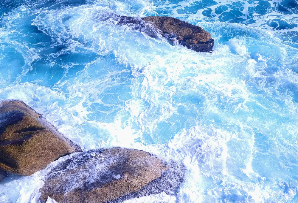 高清摄影  海浪拍打着蓝色海洋中的岩石。