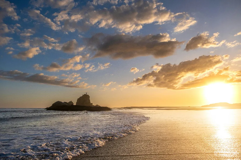 高清摄影  夕阳正落海平线上，远处有一座小岛。