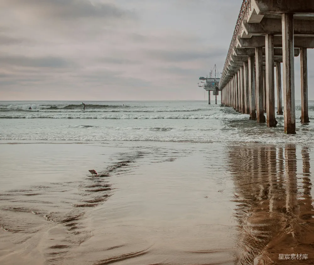高清摄影  在多云的天气中，一座桥梁延伸到海洋之上。