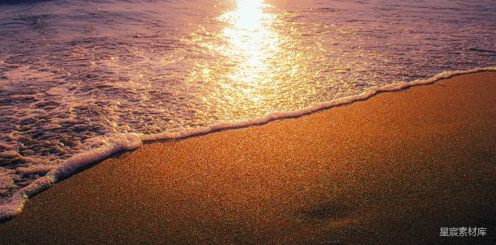 高清摄影  海浪在日落时拍打着沙滩。