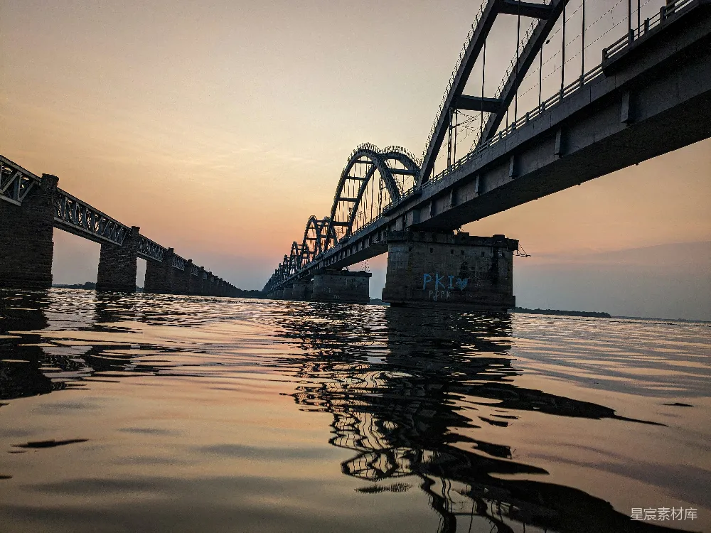 高清摄影  夕阳下的水面上的一座桥