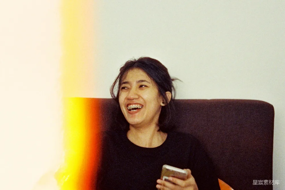 高清摄影 壁纸 人物 电影 一个女人边笑边拿着手机。