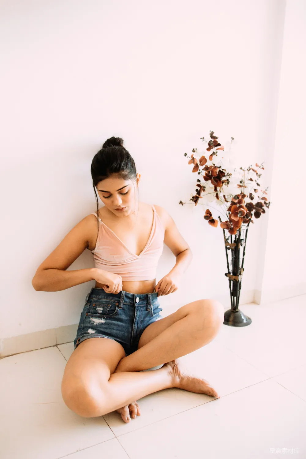 高清摄影  穿着棕色背心和蓝色牛仔短裤的女人坐在吧台凳上。