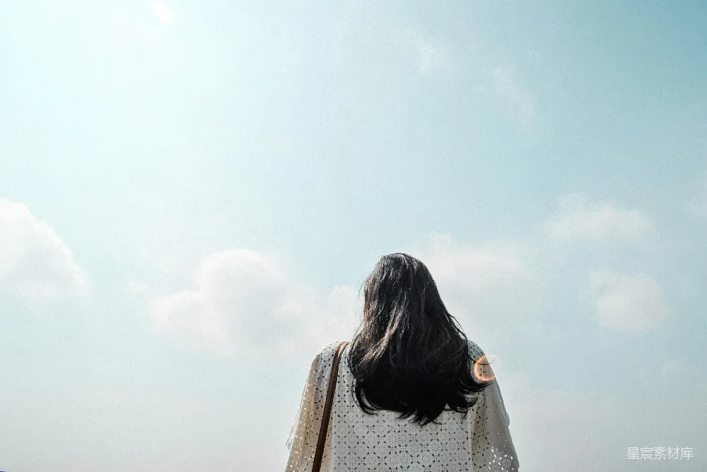 高清摄影  白天，一个女人站在多云的天空下。