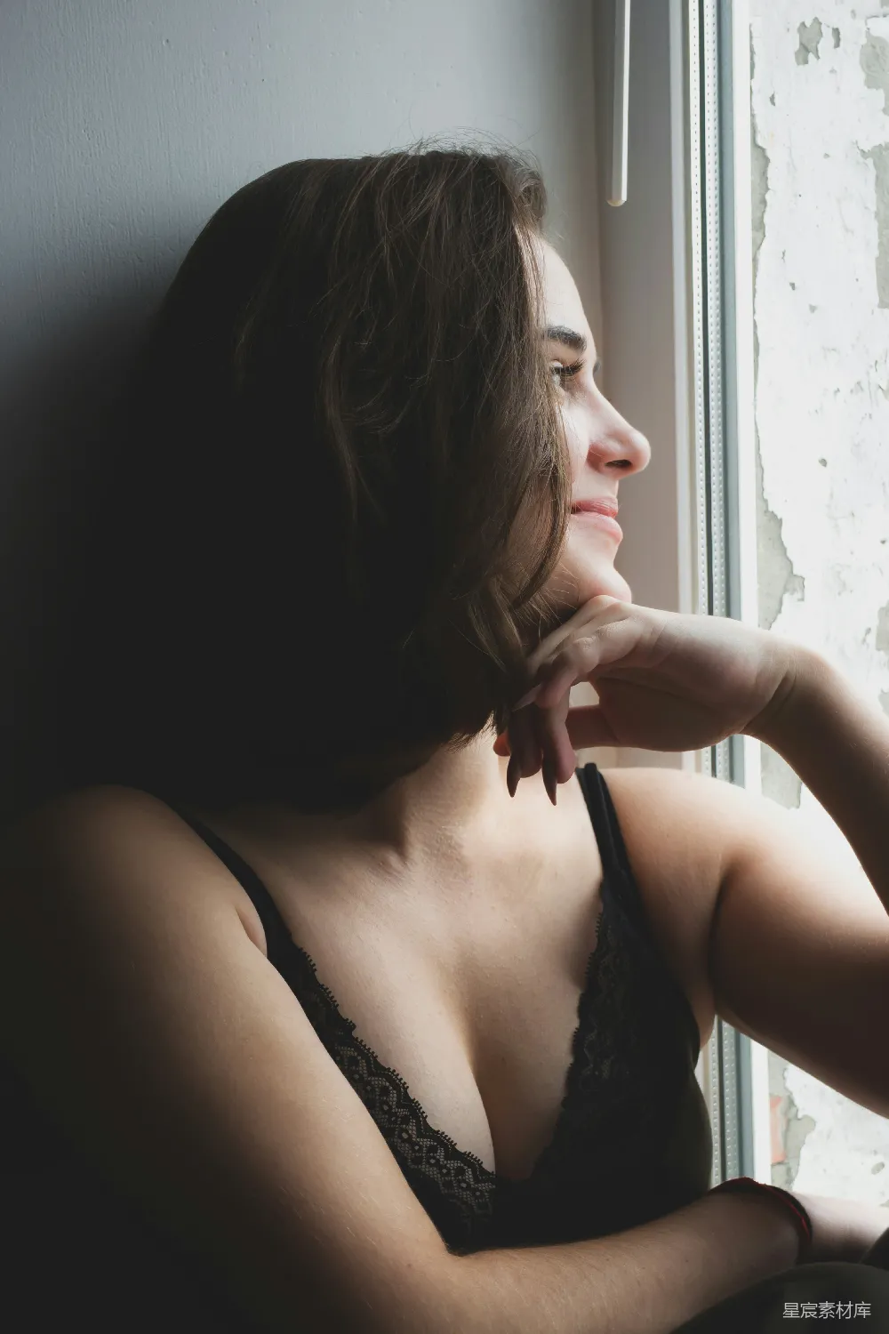 高清摄影  穿着黑色内衣的女人坐在黑色沙发上。