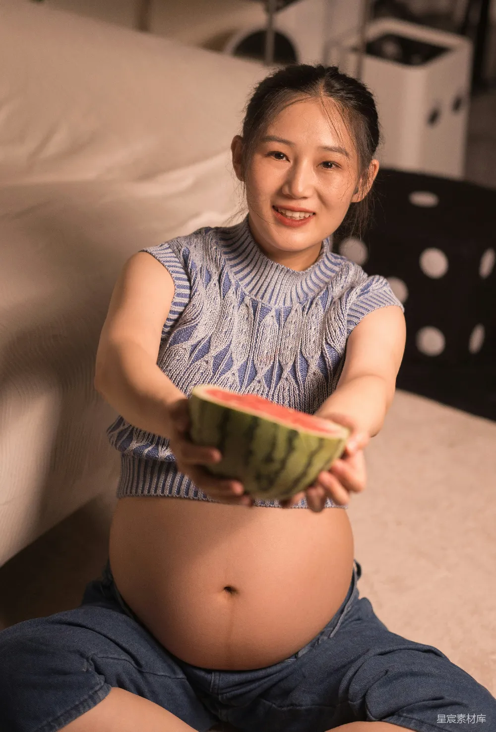 高清摄影  一个孕妇坐在地上，手里拿着一个碗。