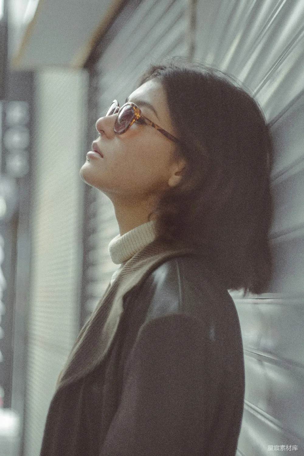 高清摄影 人物 一个戴着眼镜的女人靠在墙上。