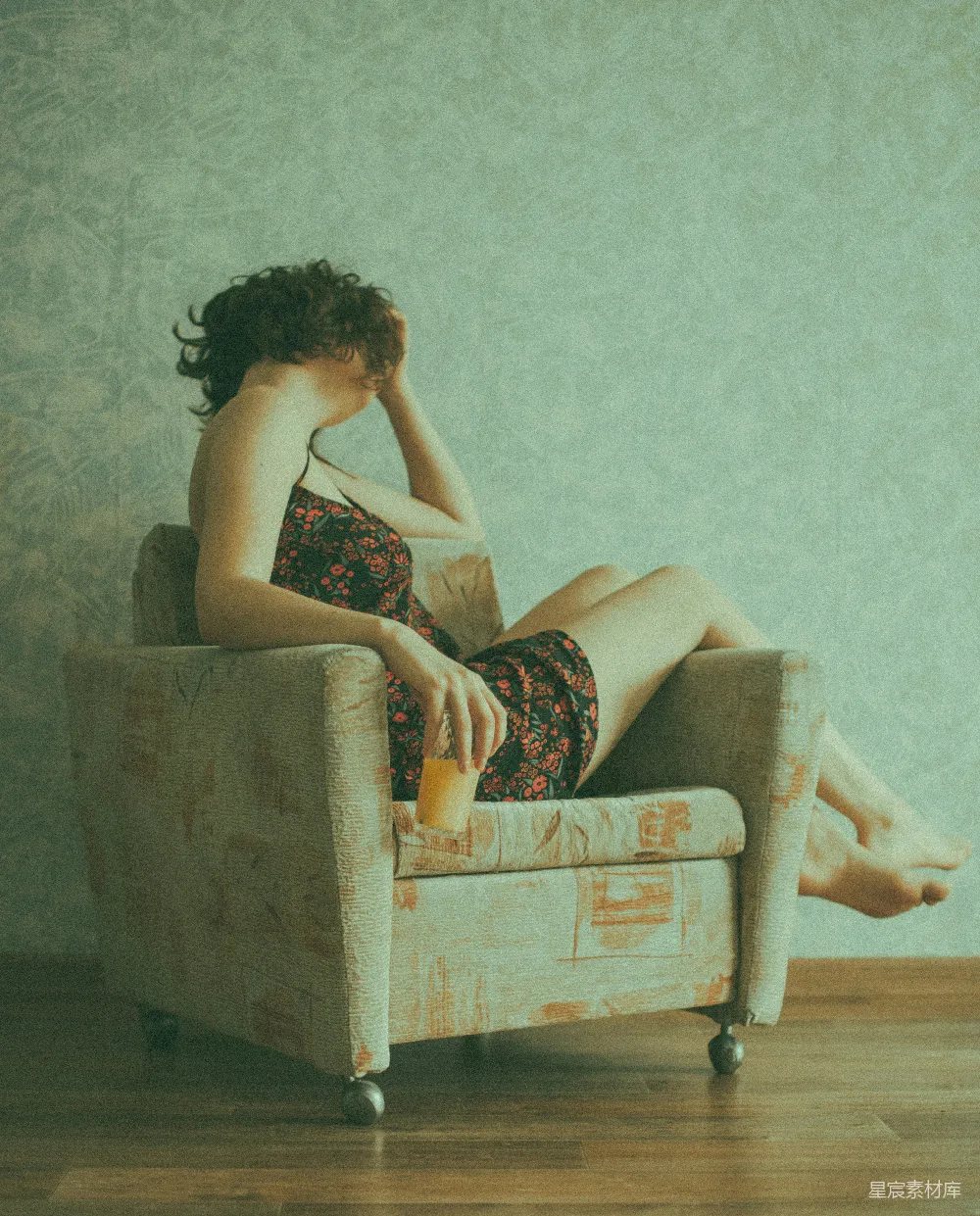 高清摄影  穿着黑色和红色花卉连衣裙的女人坐在棕色沙发椅上。