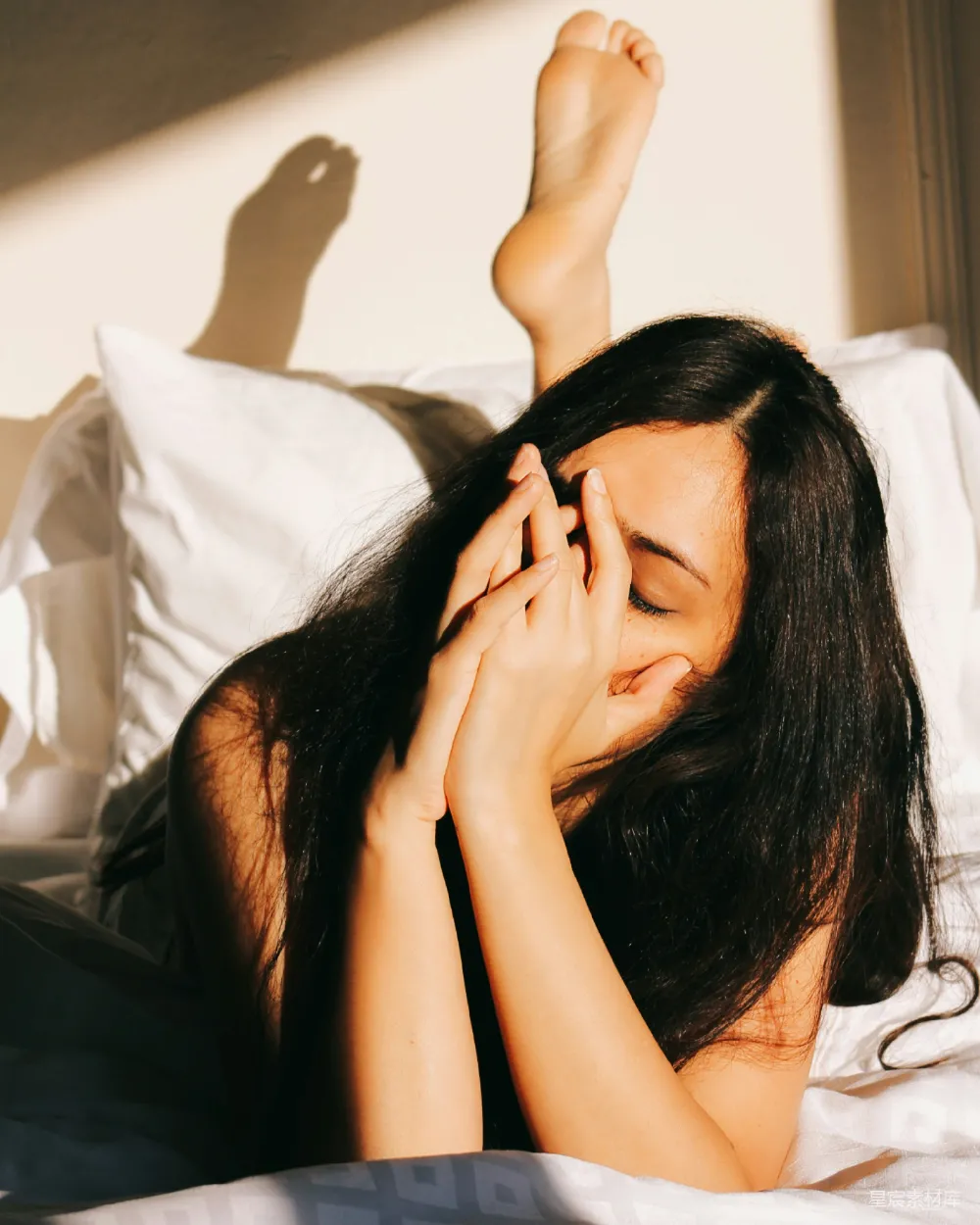 高清摄影 人物 一个女人躺在床上，双手放在脸上。