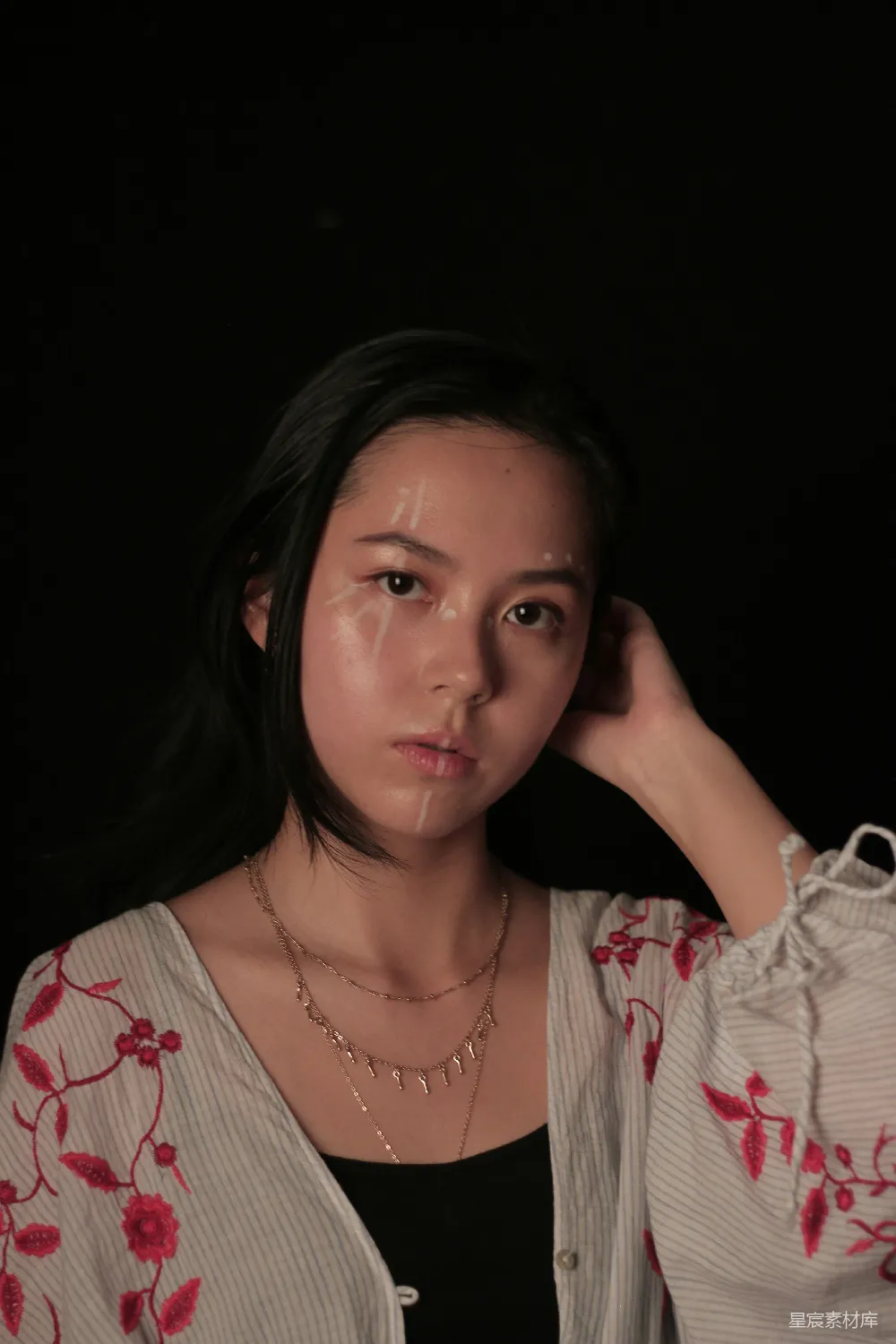 高清摄影  一个女人摆姿势拍照，手放在头上。