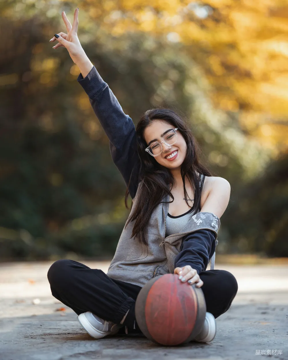 高清摄影  微笑的女子在户外拿着篮球摆姿势。