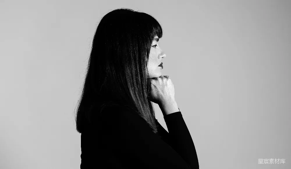 高清摄影  一位女士站在镜子前，手托着下巴。