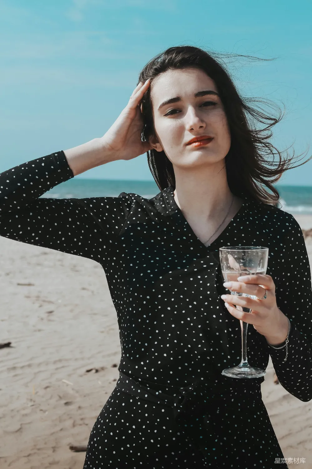高清摄影  穿黑色V领长袖衬衫的女人拿着一个透明的酒杯