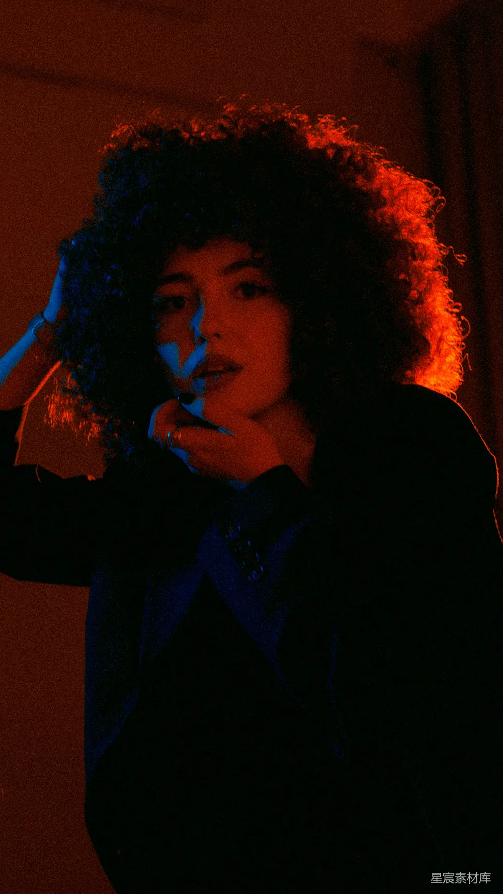 高清摄影  一个卷发的女人正把她的手放在耳边。