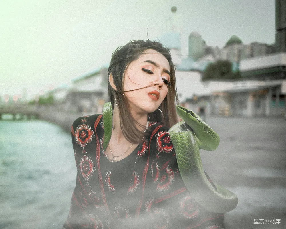 高清摄影  穿着黑色和粉色花卉长袖衬衫的女人手里拿着绿色的香蕉