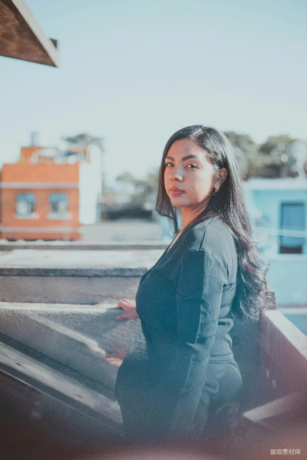 高清摄影  一个穿着黑色西装的女人站在屋顶上。