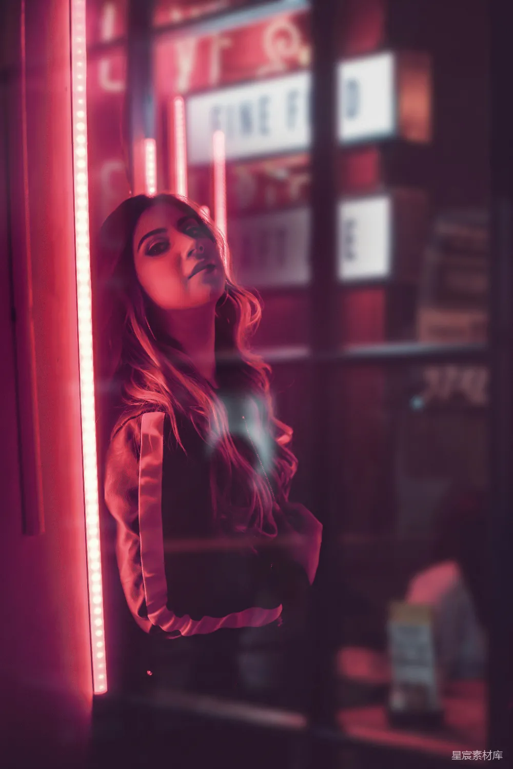 高清摄影 人物 穿红色和黑色外套的女人站在玻璃窗旁边。