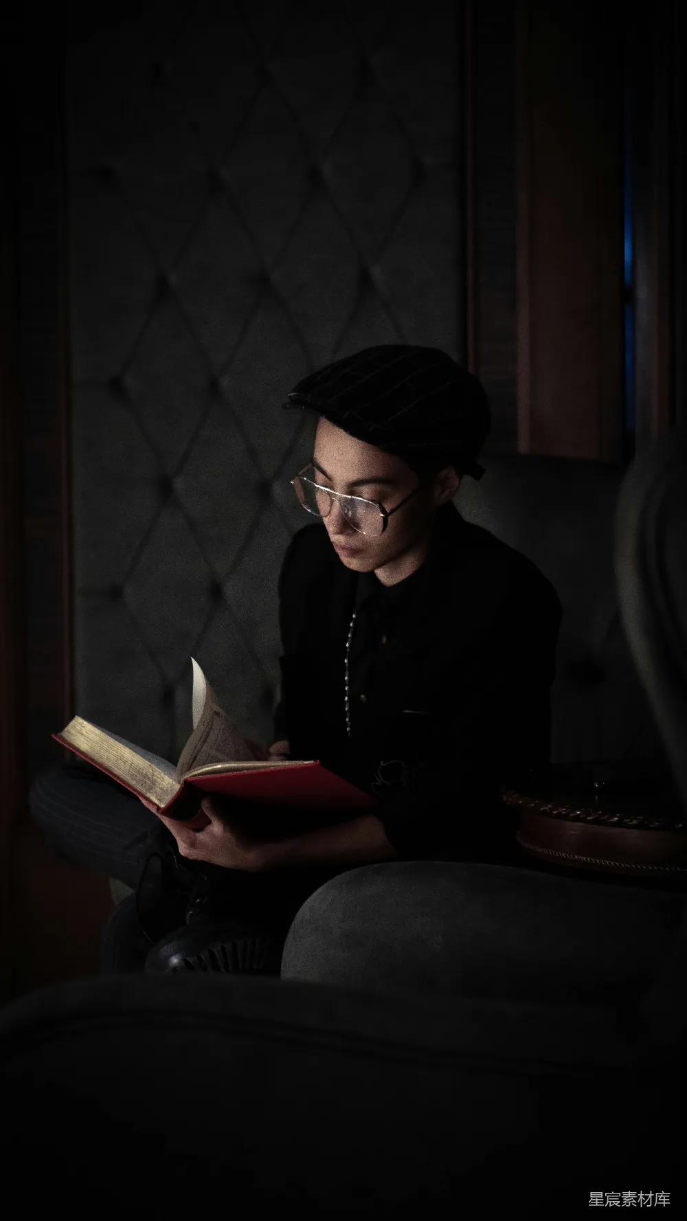 高清摄影  一个女人坐在椅子上看书。