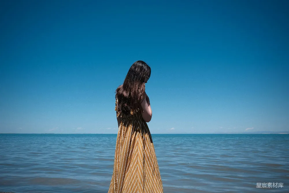 高清摄影  一位站在水中的女人在看海。
