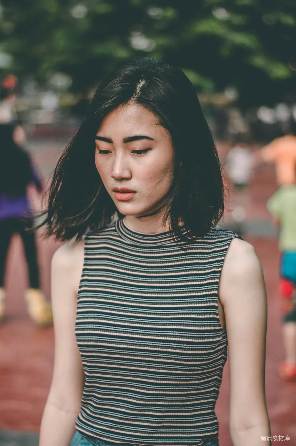 高清摄影  穿着棕色和蓝色无袖衬衫的女人站着。