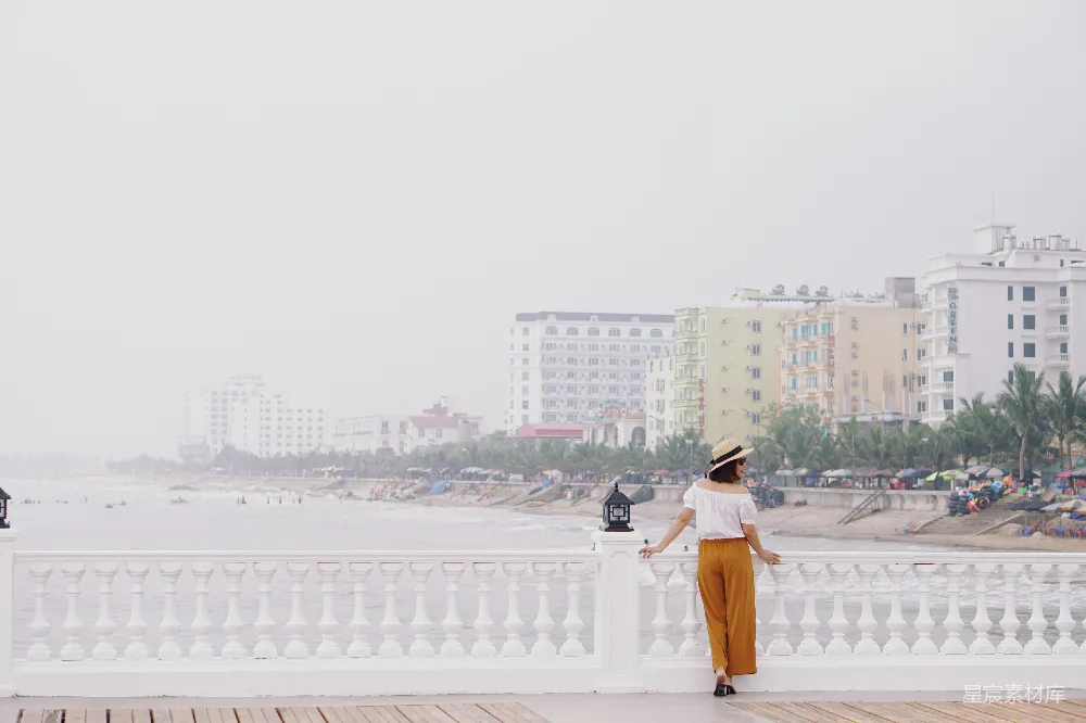 高清摄影  一个女人站在混凝土围栏旁边。