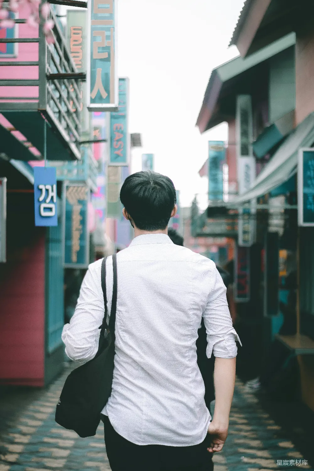 高清摄影 人物 一个穿着白色衬衫和黑色夹克的男人在白天的路边行走。
