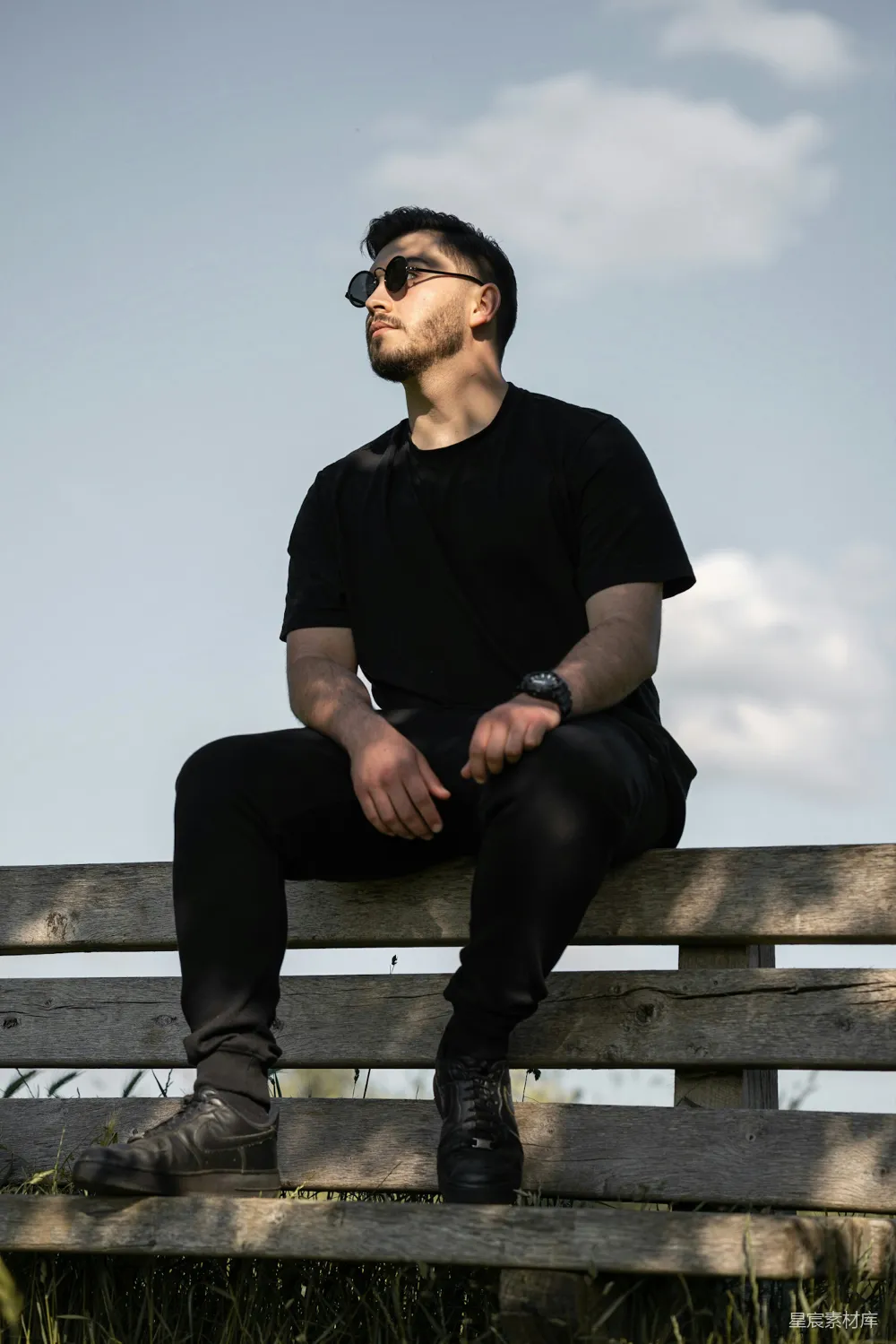 高清摄影  一个男人坐在一个木制的长凳上。