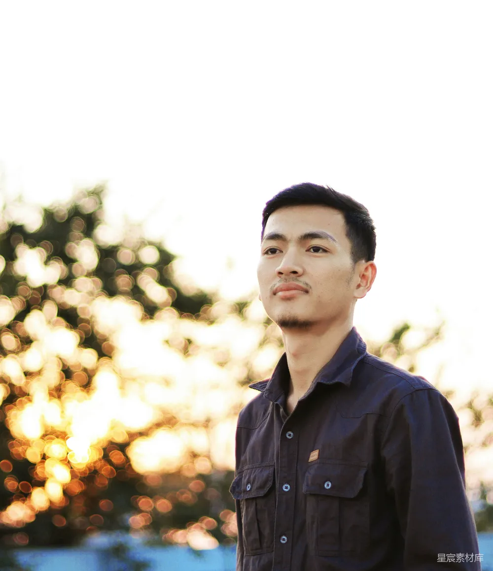 高清摄影  一个男人站在一棵树前，夕阳西下。