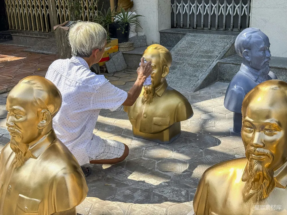 高清摄影 人物 一个男人跪在一群金色雕像旁边。
