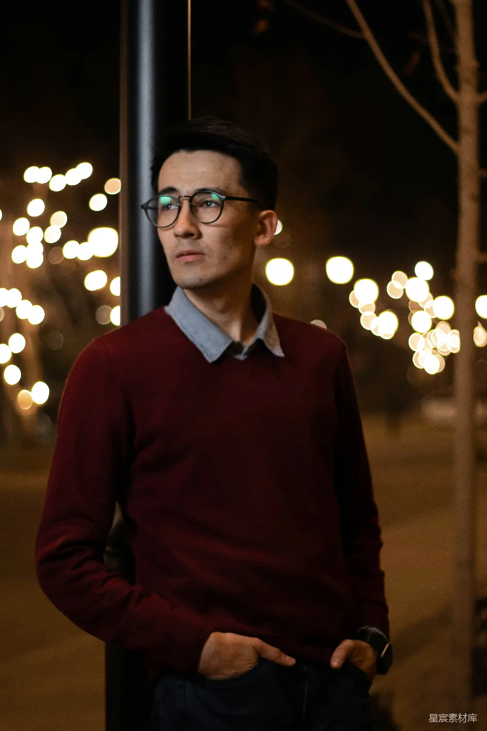 高清摄影  一个戴眼镜的男人站在一根杆子旁边